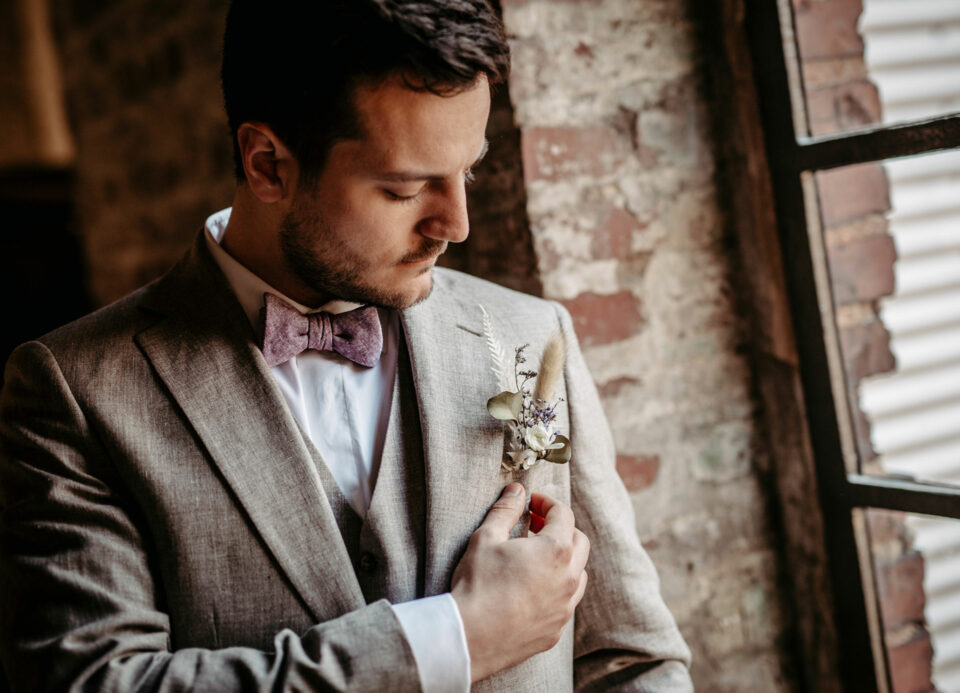 Hochzeitsanzug beige mit natürlichem Blumengesteck im Revers